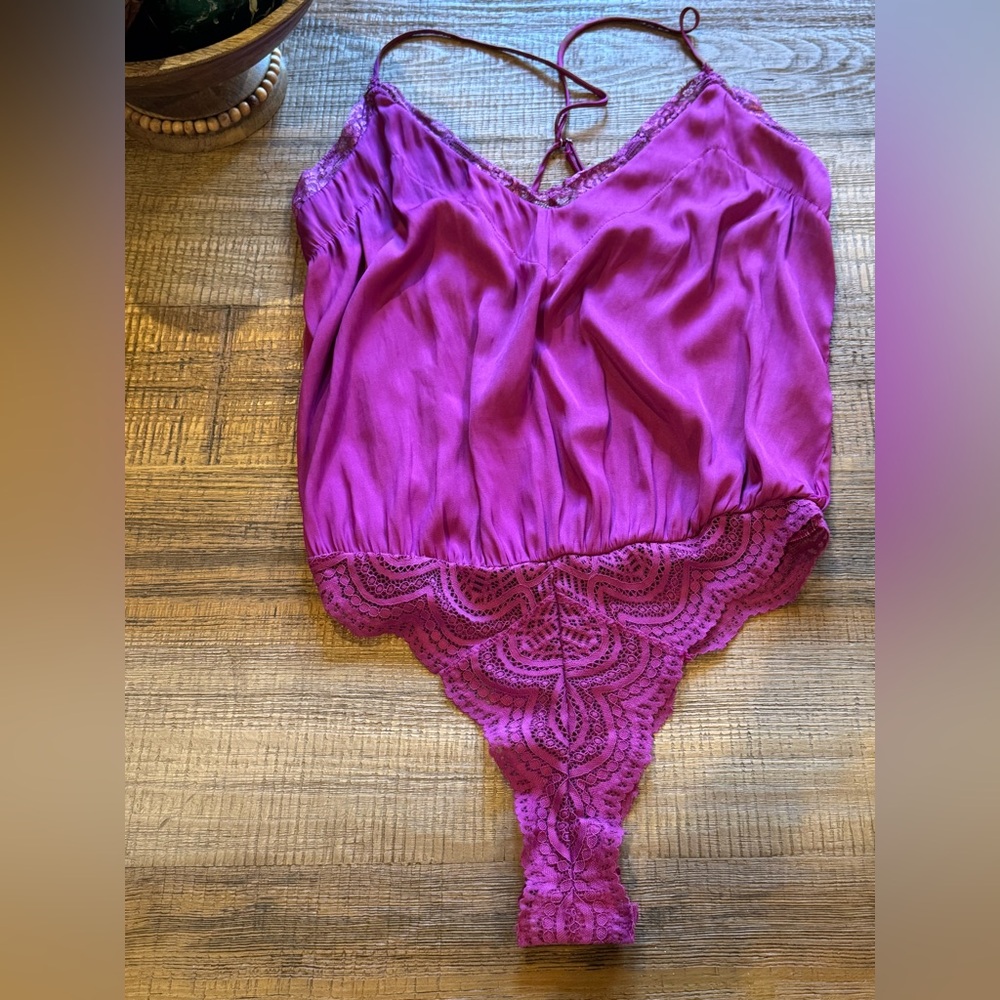 Free People's intimate purple lace bodysuit with a V-neck and sleeveless design.